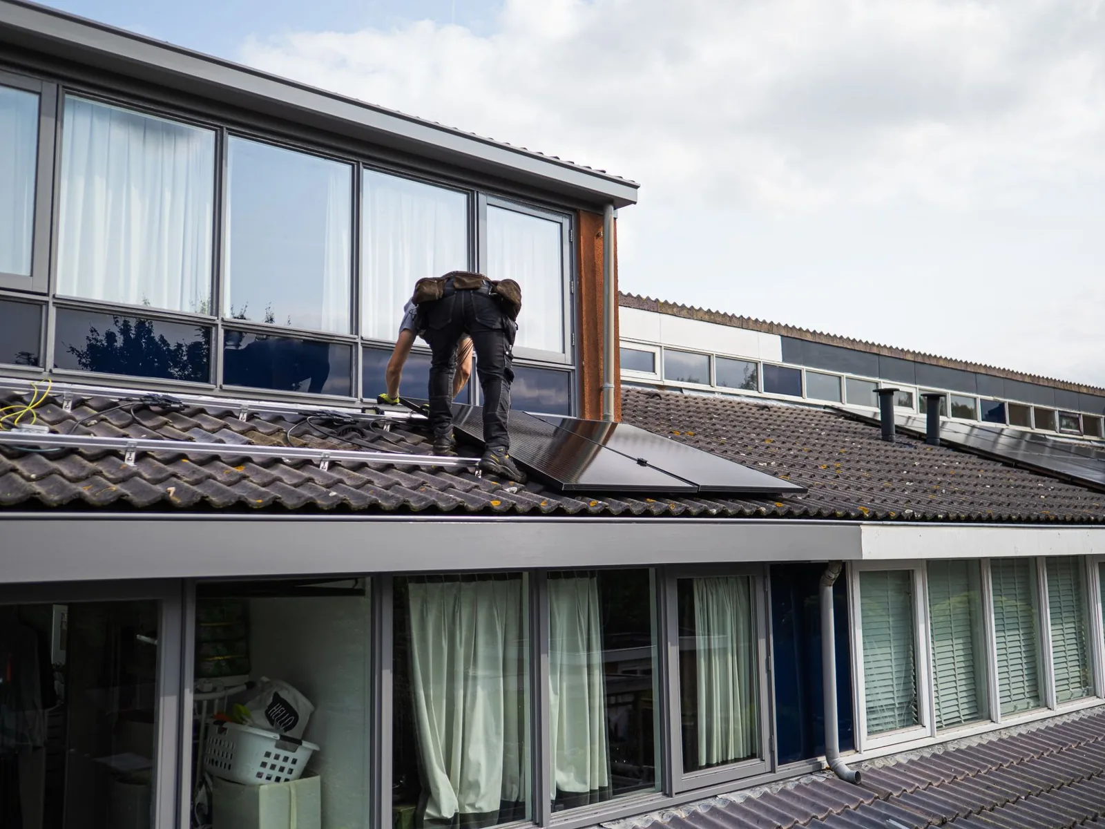 Installer securing a solar panel to a residential roof
