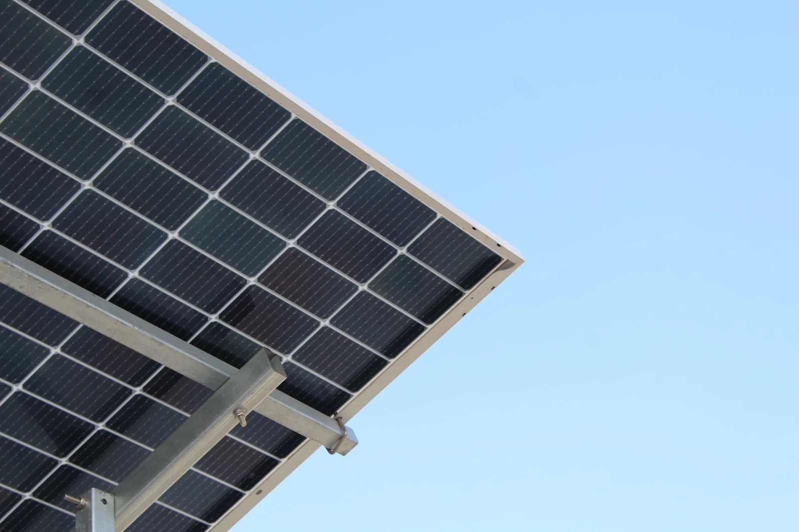 Row of solar panels being installed across a residential roof by an installer in a safety harness