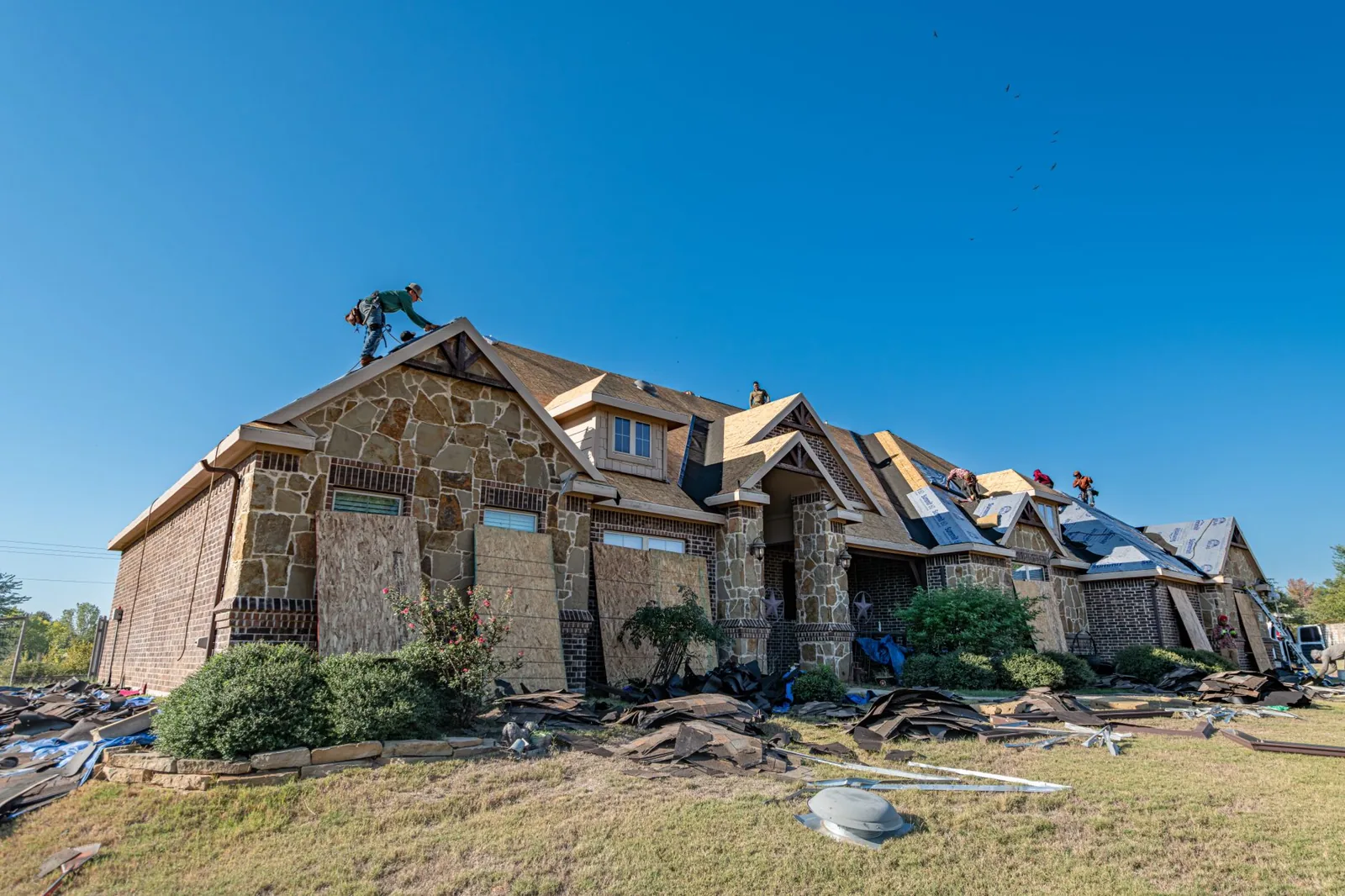 A crew replacing architectural asphalt shingles on a 2,000 square foot home